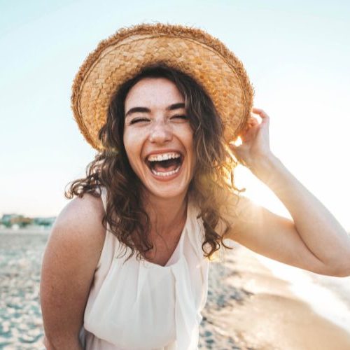 Lachende junge Frau am Strand