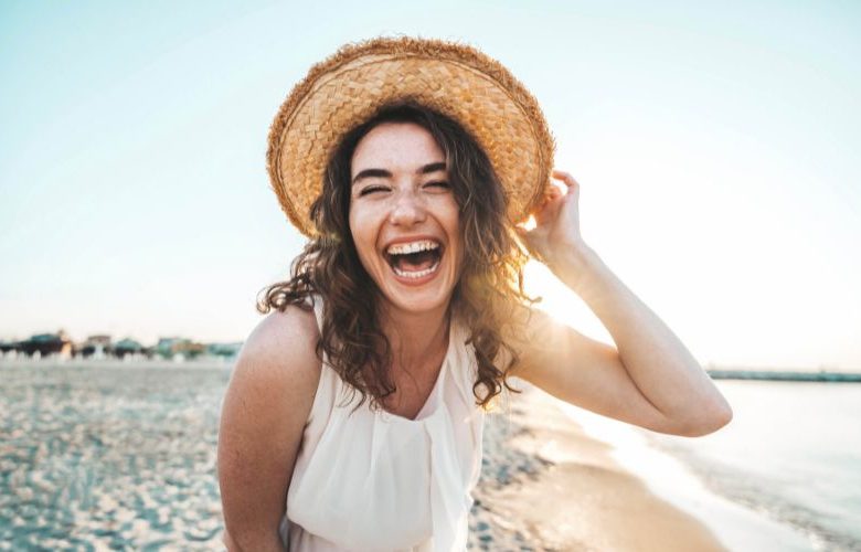 Lachende junge Frau am Strand