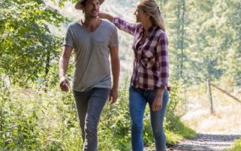 Paar spaziert auf einem Wanderweg durch das Sauerland und genießt das schöne Sommerwetter