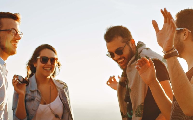 Vier freudestrahlende menschen tanzen in der Sonne